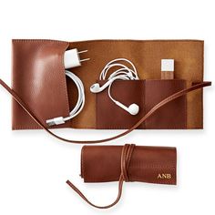 an electronic device and charger in a leather case with cords attached to the back