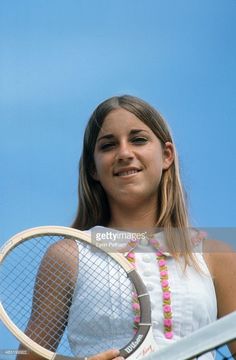 a woman holding a tennis racquet on top of a blue sky background stock photo