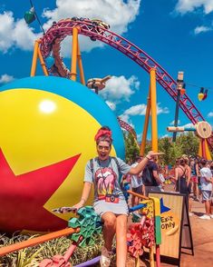 a woman sitting on top of a giant ball at an amusement park