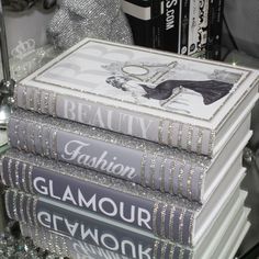 a stack of books sitting on top of a table next to a glass case filled with bottles