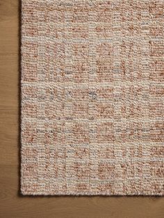 a brown and white rug on top of a wooden floor