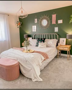 a bedroom decorated in green and pink with pictures on the wall above the headboard