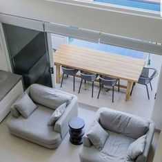 an overhead view of a living room with two couches and a table in the background