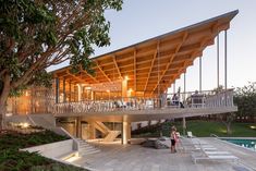 a large wooden structure sitting on top of a lush green hillside next to a swimming pool