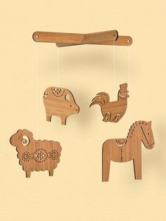 four wooden animals hanging from strings on a wall