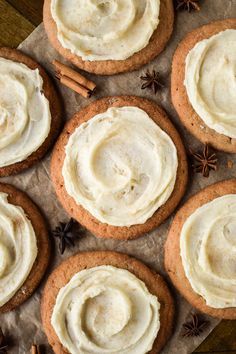 several cookies with white frosting and cinnamon sticks on the top one has anisette