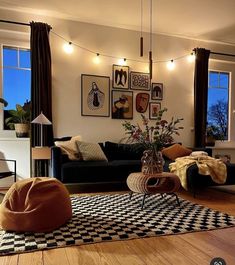 a living room filled with lots of furniture and pictures on the wall above it's windows