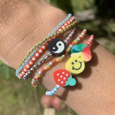 a person's arm with three bracelets on it, one has a smiley face