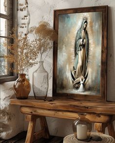 an image of the virgin mary on display next to a table with candles and vases