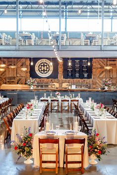 tables and chairs are set up in the center of an indoor venue with large windows