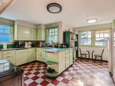 an old fashioned kitchen with green cabinets and checkered tile flooring on the floor