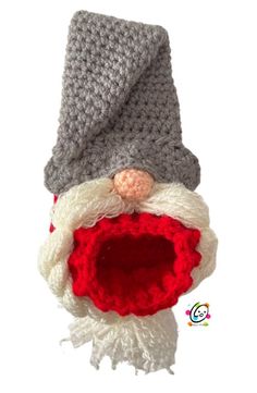 a crocheted santa claus hat with a red ball in the middle and white beard