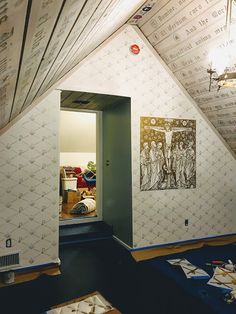 an open door leading into a room with wallpaper on the walls and carpeted floor