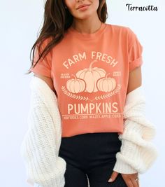 Embrace the autumn season with our Farm Fresh Pumpkins Shirt, featuring a charming design of three pumpkins with the words "Farm Fresh Pumpkins Hayrides, Corn Mazes, Apple Cider." Perfect for trips to the pumpkin patch, this pumpkin crewneck offers the cozy comfort of Comfort Colors. Ideal for any fall outing, this pumpkin patch shirt is a must-have in your collection of autumn tees. Whether you're sipping apple cider or enjoying a hayride, this fall crewneck provides both warmth and style. Add Cute Pre-shrunk Shirt For Fall, Cute Fall T-shirt With Relaxed Fit, Fall Soft-washed Relaxed Fit Shirt, Soft-washed Comfort Fit T-shirt For Fall, Soft-washed Comfortable T-shirt For Fall, Soft-washed Relaxed Fit Shirt For Fall, Fall Cotton Shirt In Orange, Orange Cotton Shirt For Fall, Comfortable Fit Graphic Tee For Fall