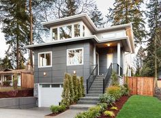 a gray house with stairs leading to the front door