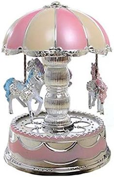 a pink and white carousel with horses on it's sides, in front of a white background