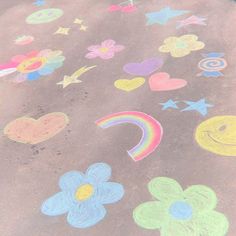 the sidewalk is covered in chalk and has flowers, hearts, stars, and rainbows drawn on it