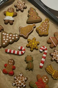 an assortment of decorated christmas cookies on a baking sheet with icing and candy canes