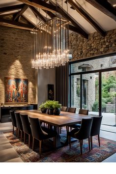 a dining room with a large wooden table surrounded by black chairs and chandeliers