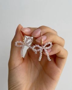 a woman holding two small crystal starfish earrings