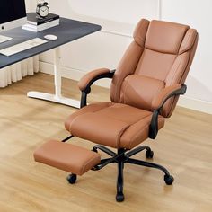 an office chair and footstool in front of a computer desk