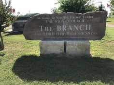 a large stone sign sitting in the grass