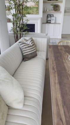 a white couch sitting next to a wooden table