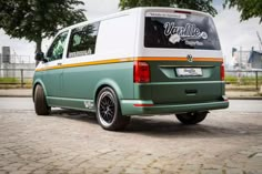 a green and white van is parked on the street