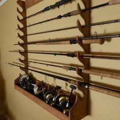 a wall mounted fishing rod rack with several rods and reels hanging on the wall