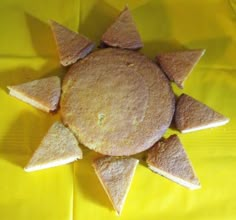 some food that is on top of a yellow table cloth and has been cut into triangles