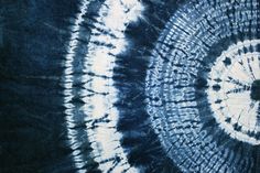 a tie - dyed blue and white background with an abstract design in the center that is spirally shaped