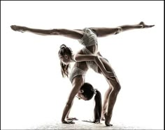 two women doing yoga poses in front of a white background