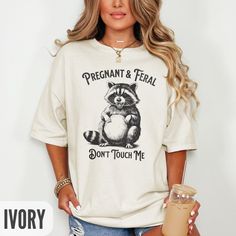 🥳🍾 Help me celebrate my one year anniversary of opening my small business with a rare 50% off flash sale!  It's the biggest discount I've ever given and is only good for today (January 17th), so make sure to get your orders in by Midnight EST! 🍾🥳 Celebrate the wild ride of pregnancy with this hilarious "Pregnant & Feral" raccoon graphic tee - a perfect blend of humor and sass for moms-to-be. Featuring a detailed, quirky raccoon illustration and bold text, this shirt is a fun way to express t Feral Raccoon, Raccoon Illustration, Maternity Graphic Tees, Funny Maternity, Funny Pregnancy Shirts, Raccoon Shirt, Funny Pregnancy, Pregnancy Wardrobe, Dont Touch Me