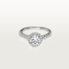 a white gold engagement ring with round diamonds on the band and an oval center stone