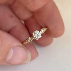 a person holding a diamond ring in their hand