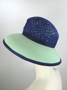 You'll look great in this pretty green and navy wool felt hat! It can easily transition from Winter to early Spring and is perfect for any dressy occasion. Imagine walking into church with this beauty! The flattering asymmetrical wide brim hat had a slight turned down brim with a cut out on the right side. It's topped with a gorgeous, extra wide ombre navy and green five loop bow that has a gorgeous Czech glass button in the center. This hat that will be the envy of everyone who sees it! The top Blue Curved Brim Felt Hat For Parties, Blue Curved Brim Felt Hat For Party, Blue Felt Hat With Curved Brim For Party, Blue Fitted Wide Brim Cloche Hat, Blue Wide Brim Cloche Hat, Brimmed Felt Hats For Kentucky Derby, Kentucky Derby Fur Felt Hat, Green Felt Hat With Curved Brim For Summer, Summer Green Felt Hat With Curved Brim