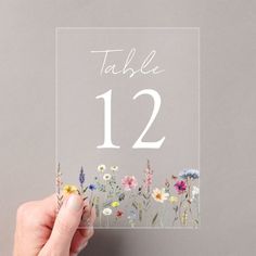 Enhance your wedding decor with our Elegant Wildflower Meadow Wedding Table Number Cards. These stunning cards feature a border of watercolor wildflowers and foliage in soft shades of pink, yellow, purple, blue, and green, beautifully framing the bottom of the design. Set against a frosted or transparent acrylic background, the rustic wildflower theme is ideal for spring and summer weddings. To personalize, simply add each table number to your cart individually and proceed to checkout when you'r Wildflower Wedding Table Numbers, Wedding Acrylic Table Numbers, Stained Glass Table Numbers, Garden Party Table Numbers, Spring Wedding Table Settings, Wildflower Wedding Decorations, Diy Wedding Seating Chart, Wedding Seating Chart Table, Flower Place Cards