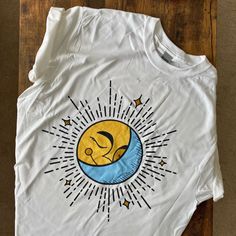 a white t - shirt with an image of a sleeping baby on the moon