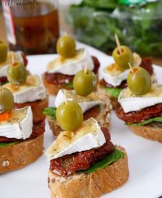 small sandwiches with olives and cheese on them