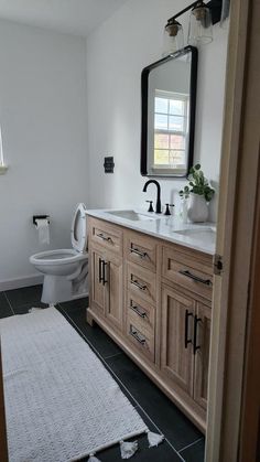 a bathroom with a sink, toilet and mirror in it's centerpieces