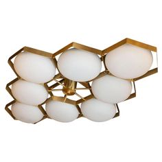 an image of a modern light fixture with white glass balls on the bottom and gold metal frame