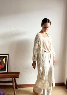 This long cardigan, has a gorgeous crochet stitch 100% handmade. This cotton kimono cardigan has a beautifull open closure. This beige crochet cover up is made with hight quality cotton yarn, anti allergic and super super soft. This amazing maxi cardigan is the gargment that you would want wear it forever! Perfect to wear it with dresses or with a jean! Super comfortable, stylish and versatile! WHICH IS MY SIZE? This long cardigan is available in different sizes.  In order to know which is the perfect size for you, you just have to measure your chest . Below, you can find the measurements referred to every size: Measurements referring to the chest contour:  Size S: 80 cm / 32 in. Size M: 90 cm / 35 in. Size L: 100 cm / 39 in. If you can't find your size or you are not sure about the size, Long Open Knit Crochet Dress As Beach Cover-up, Long Open Knit Crochet Dress For Beach Cover-up, Long Open Knit Crochet Beach Cover-up Dress, Long Open Knit Crochet Dress For Beach, Long Winter Cardigan For Vacation, Long Winter Vacation Cardigan, White Oversized Bohemian Cardigan, Long Cardigan For Beach In Winter, One Size Cozy Cardigan For The Beach