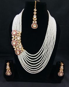 The base metal color is Gold tone studded with white kundan stone . This jewellery set consists of a necklace and a matching pair of earrings and a mangtika Off-white gold-plated beaded and kundan-studded layered necklace, secured with drawstring closure A pair of matching drop earrings, secured with a post and back closure White Tilla Bridal Necklace For Diwali, Bollywood Bridal Necklace With Tilla In White, White Kundan Chandbali Pearl Necklace, Bollywood Style White Tilla Bridal Necklace, Festive White Pearl Jewelry Sets, Hand-set White Pearl Necklace, Hand Set White Pearl Necklace, White Kundan Bridal Necklace For Celebration, Bollywood White Jewelry For Diwali