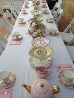 the table is set with pink and gold china