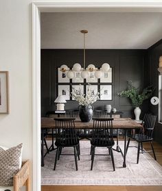 a dining room with black walls and wooden floors