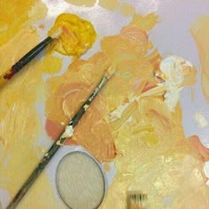 two paintbrushes sitting on top of a painting