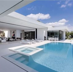 an empty swimming pool in front of a modern house