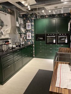 a kitchen with green cabinets and wooden counter tops in an industrial style home or office