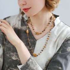 This natural stone necklace combines raw stones of different materials and shapes, creating a simple and natural original ecology with a touch of Zen aesthetics. The beautiful earth-tone design is perfect for all seasons and can be worn alone or stacked with a white fossil necklace for a stunning look. Embrace the beauty of nature with Planet Trail. Metal: 18K Recycled Gold Plated On Brass Gemstone: Tiger's Eye,Tea Crystal,Picture Stone,Other Natural Stone Length: 1040-1090mm Weight: 38g Edison Pearls, Natural Stones Necklace, Gemstone Beaded Necklace, Long Beaded Necklace, Unique Coffee, Tiger Eye Stone, Raw Stone, Recycled Gold, Stone Necklace