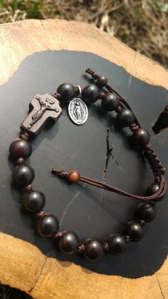 +. This is a Wooden Rosary Bracelet. +.It is knotted bracelet and it is adjustable . +.The crufix is carved in elevorate and three dementional shape. +.+.+.+.+. Materials +.+.+.+.+.+. Cross: Mpingo(Africa black wood) Beads : black wood +.+.+.+.+. Size +.+.+.+.+. Cross : 13.3mm(Width) *20mm(Height) Beads: 8mm +. Carved characters(e.g. baptismal name, name,etc) on back side +. please send me characters that you want. It's Free engraving +.Lead time is 3-7 business days. +.Delivery is currently bei Adjustable Wooden Beads Rosary Bracelet Gift, Adjustable Wooden Bead Rosary Bracelet Gift, Diy Rosary, Knotted Rosary, Bracelet Rosary, Mens Rosary, Wooden Rosary, Rosary Jewelry, Rosary Beads Catholic